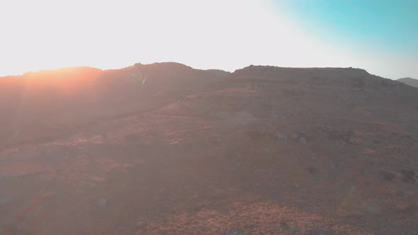 Drone flying towards small house on mountain