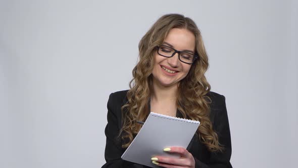 Girl Takes Pencil, Notebook and Draws Schemes, Then Happily Hugs Notebook