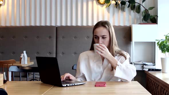 Young businesswoman on a coffee break. Using tablet computer.