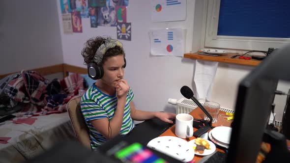 Young Boy with Gaming Headphones Looking Frustrated at Monitor