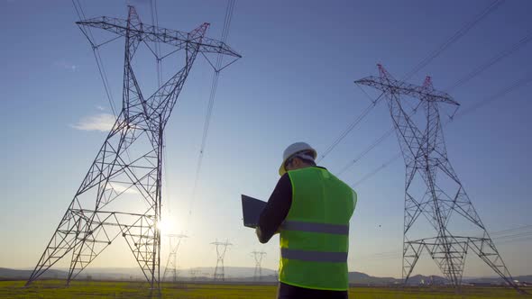 Electrical engineer working in front of high voltage lines.