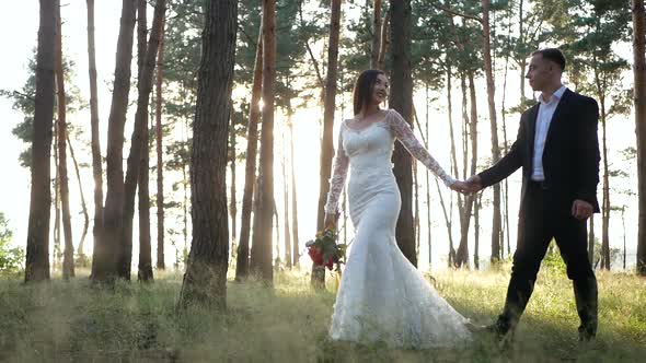 Groom and Bride in a park. wedding dress. Bridal wedding bouquet of flowers, love the groom