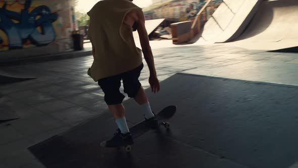 Hipster Man Enjoying Extreme Sport with Skateboard in Urban Skate Park