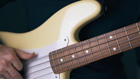 Bassist Tunes White Bass Guitar Strings By Hands and Frets