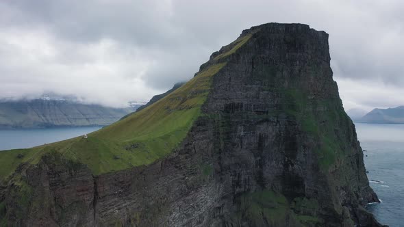 Flight Away From a Huge Cliff with a Small Lighthouse on Kalsoy, Faroe Islands
