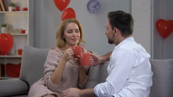 Couple on Couch Having Nice Conversation and Drinking Coffee, Togetherness