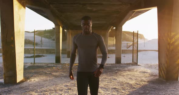 Portrait of focused african american man walking to camera, exercising outdoors in the evening