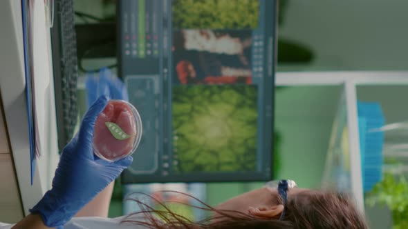 Vertical Video Biologist Woman Writing Medical Expertise While Holding Petri Dish with Vegan Beef