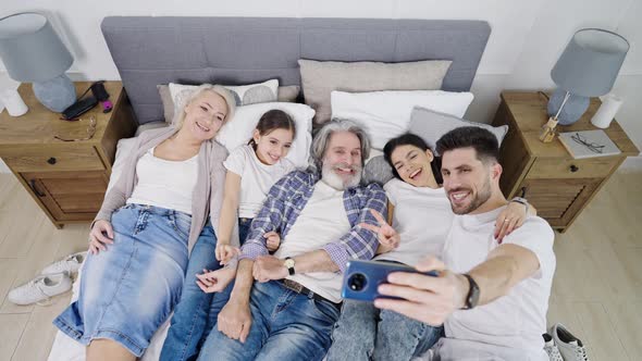 Beautiful Happy Big Family Taking Selfie While Relaxing on Bed at Home