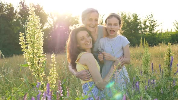 Cute Child Girl with Her Young Mother and Senior Grandmother are Having Picnic During Summer Outdoor