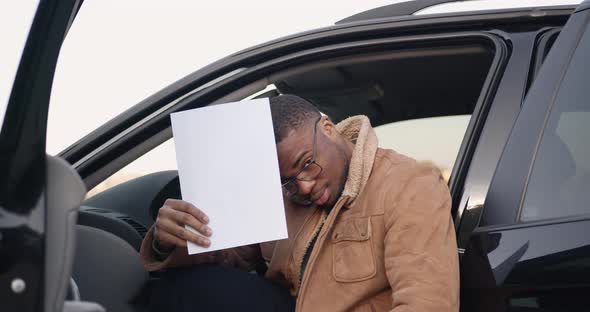 Male Driver Behind the Wheel with Sheet of Paper