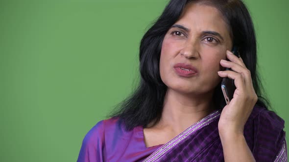 Close Up Shot of Mature Beautiful Indian Woman Talking on the Phone While Thinking