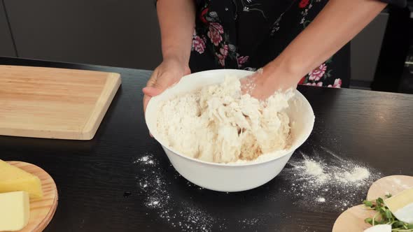 Hands knead dough