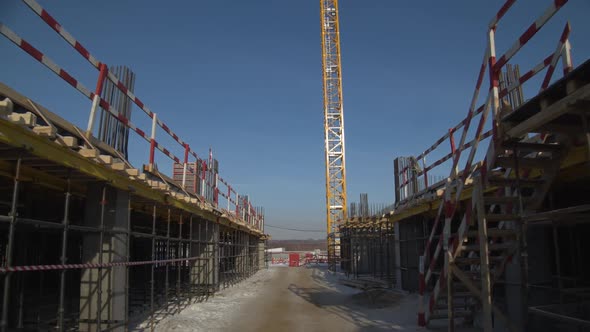 Passway Between Concrete Grounds and Workers at High Crane alt