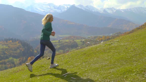 the camera follows a young beautiful woman who runs uphill down a slope
