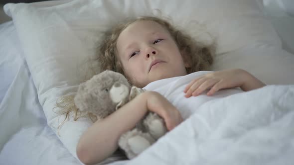 Sad Little Girl With Toy Crying in Bed, Unhappy Sick Child Feeling Lonely