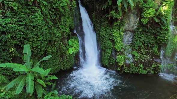 Waterfall Among Tropical Plants And Green Leaves In Bali, Indonesia.