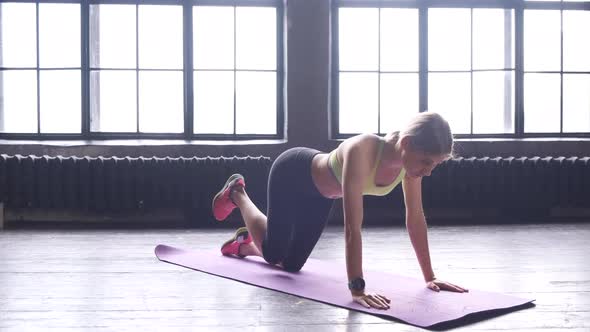 A Young Blonde Woman Is Doing A Leg Exercise Doing Sports In A Fitness Studio With Large Windows