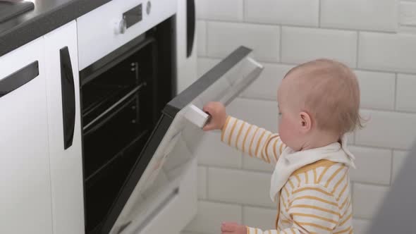 Curious Little Baby Opening Oven at Home in Kitchen