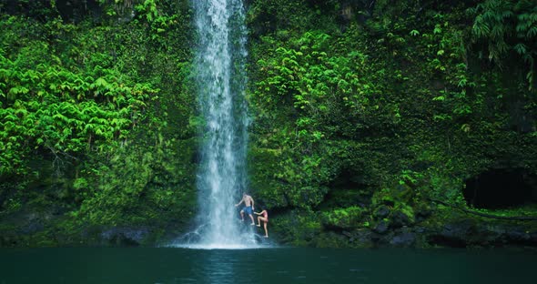 Couple Relaxing Under Waterfall