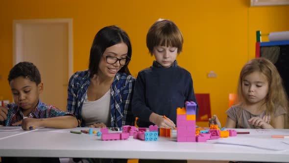 Teacher Working with Children in Preschool Class