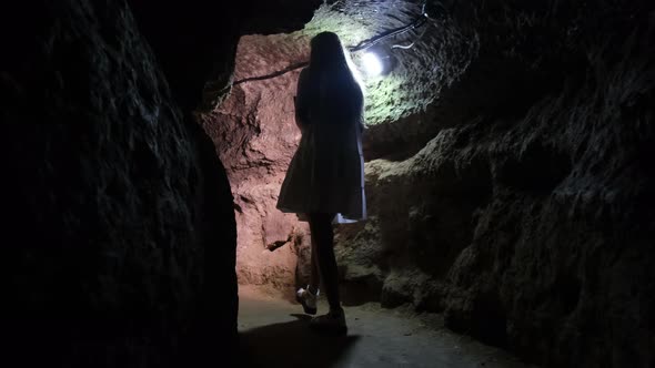 A lonely girl walks in a cave. Underground caves and tunnels