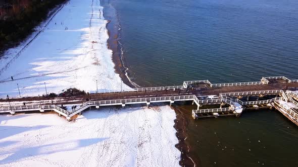Gdansk Brzezno pier in winter, aerial shot. Flying along the side of the pier, turning the camera. S