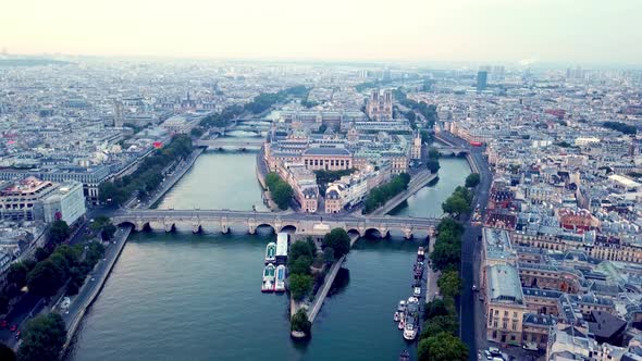 Drone flying Seine river towards Ile de la Cite with Pont Neuf bridge in foreground. Panoramic aeria