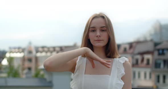 Portrait of the Young European Woman with Nose Earring in White Dress in the City She Smiles