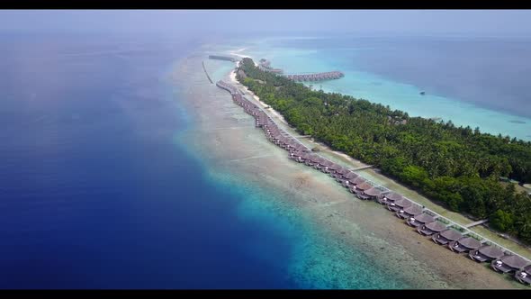 Aerial drone seascape of tropical tourist beach lifestyle by shallow ocean and white sand background