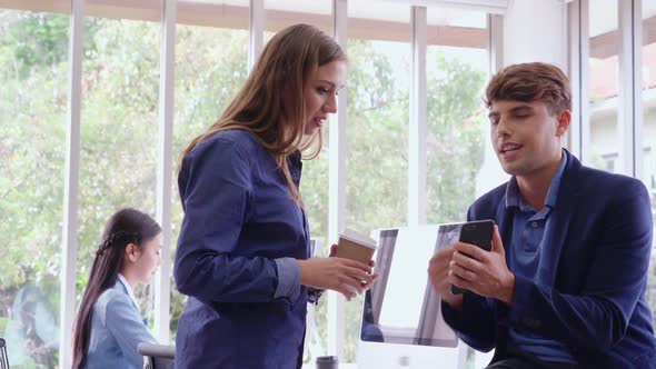 Happy Businesswoman and Businessman Having Conversation in Modern Office