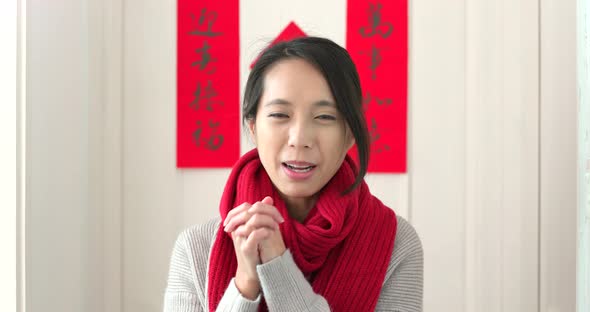 Chinese woman holding red packet and blessing for good fortune at home