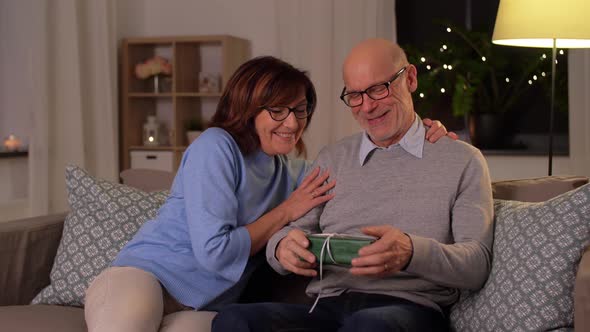 Happy Senior Couple with Gift Box at Home