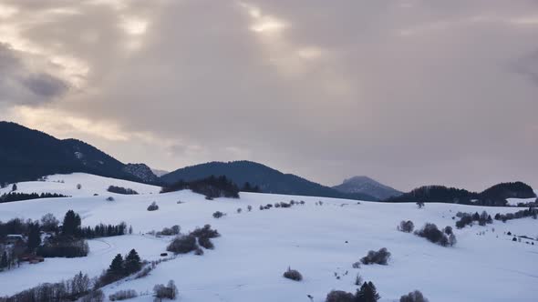 The Sun's Rays Shine Through the Dense Clouds on the Snowy Landscape