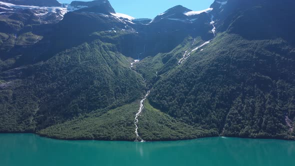 Melting glacier - Glacier river streaming from edge of icecap and down to turquoise lake Lovatnet in