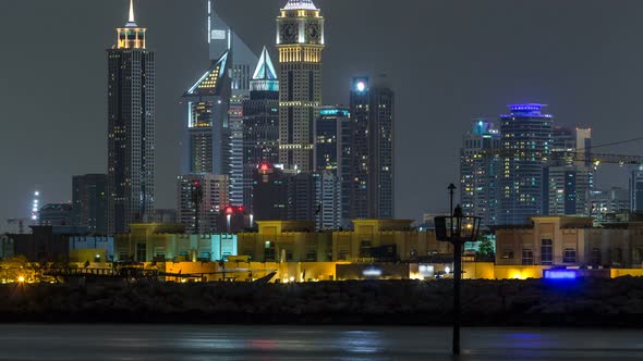 Modern Dubai City Skyline Timelapse at Night with Illuminated Skyscrapers Over Water Surface