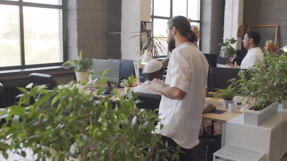 Man Talking on Phone Approaching Desk