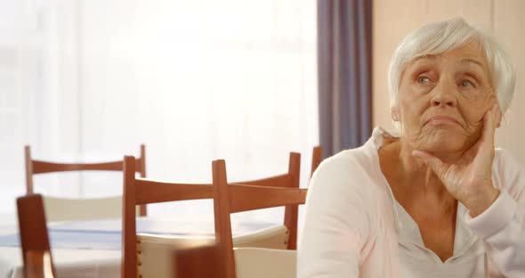 Unhappy senior woman sitting alone