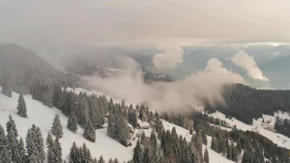 Aerial of single cabin on snow covered mountain top