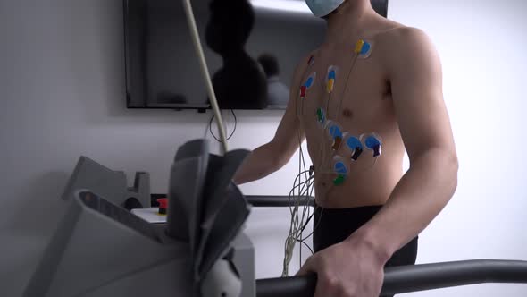 Unrecognizable man walking on treadmill during cardiac stress test