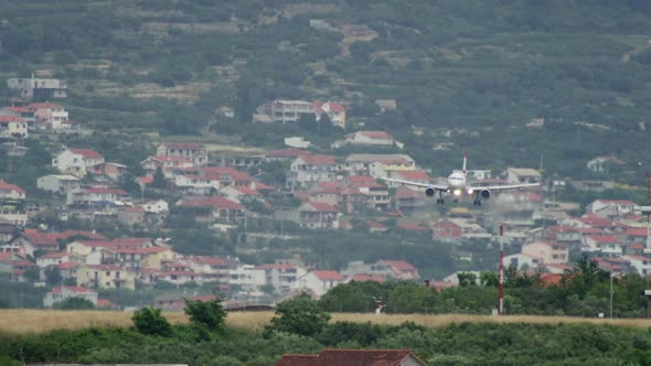 An Airplane Lands on a Runway in a Cityscape