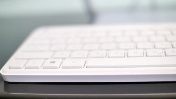 Close up on desktop keyboard on desk in office, pan shot