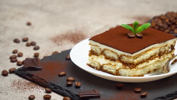 Portion of Traditional Italian Tiramisu dessert on grey concrete background