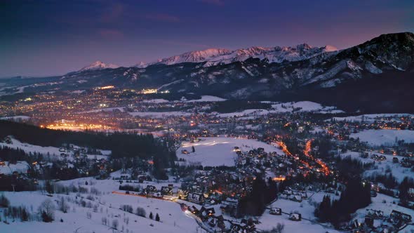 Sunset over illuminated Zakopane in winter, aerial view