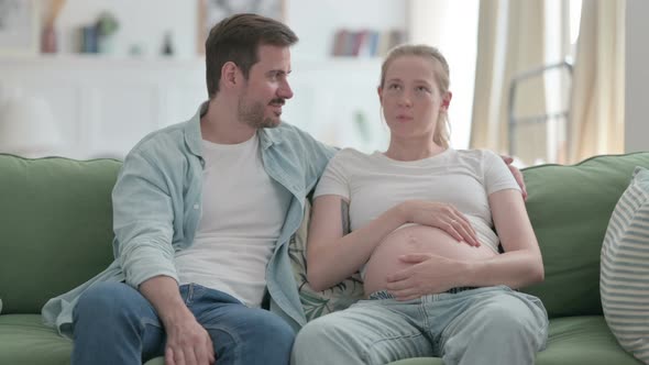 Pregnant Woman and Husband Talking with Each Other at Home