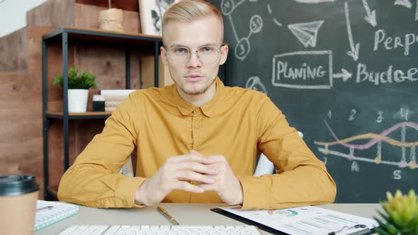 Portrait of Confident Businessman Speaking on Video Call in Creative Office