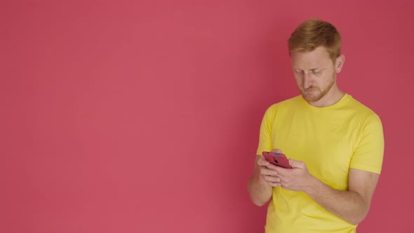 Worried Man Reading Bad News on Mobile Phone Over Isolated Red Background