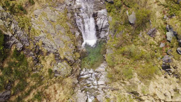 Aerial View of Waterfall Flowing Trough Rocks of Mountain