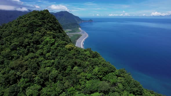 Flying over a lush Tropical mountain ridge to reveal the beautiful eastern coastline of Taiwan