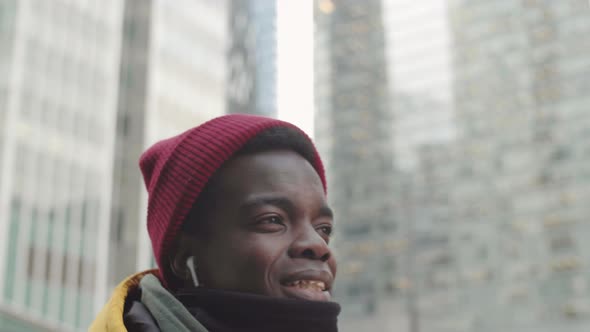 Cheerful African Man Listening to Music Outdoors